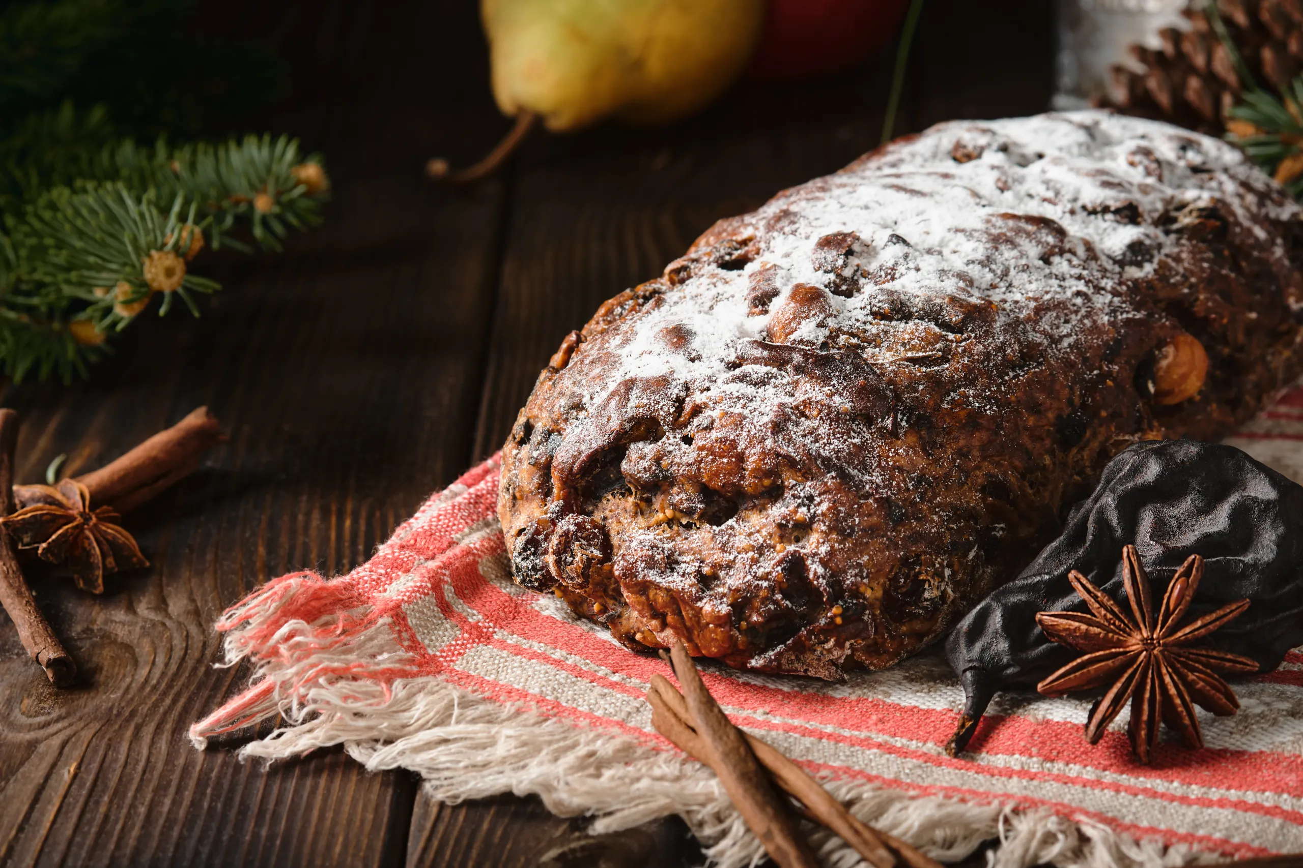 Traditional Christmas Swiss Pear Bread – Birnbrot or Birnweggen (Panelle pere) is local dish filled with dried pear fruits and nuts. Selective focus. Pie close-up on wooden table. New Year’s tea party
